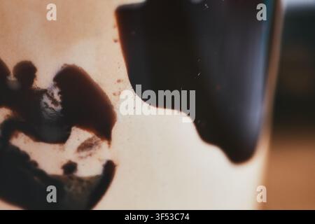Macro close-up view of rich dark coffee crema and dark liquid patterns on a pale surface inside a cup, highlighting delicious morning beverage texture Stock Photo