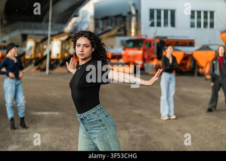 Focused woman poses while dancing with friends Stock Photo