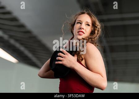 Stylish woman with curly hair holds black fedora hat Stock Photo