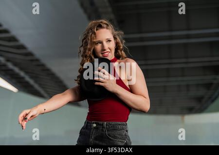 Stylish young woman with curly hair dances with a hat Stock Photo