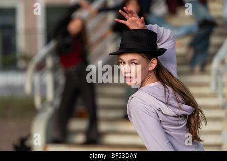 Teen girl in top hat striking a pose outdoors Stock Photo