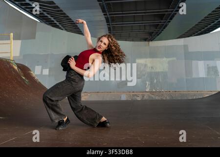 Female dancer striking a dramatic pose under a bridge Stock Photo