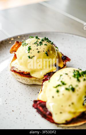 Gourmet eggs benedict with bacon and chives Stock Photo