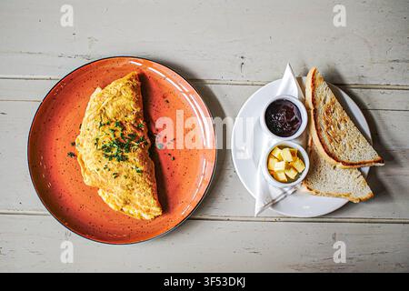 Omelette and toast breakfast on a rustic wooden table Stock Photo