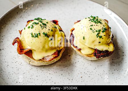 Delicious eggs benedict with bacon and chives Stock Photo