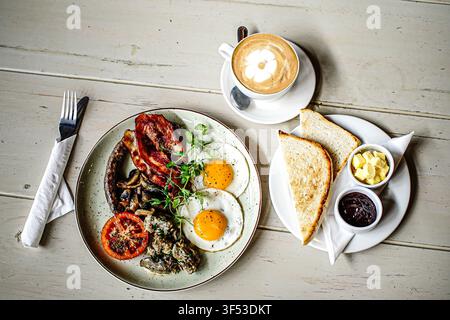 A full English breakfast with coffee on table Stock Photo