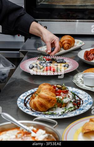 A female chef is preparing breakfasts in a restaurant. Stock Photo