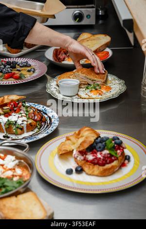 A female chef is preparing breakfasts in a restaurant. Stock Photo