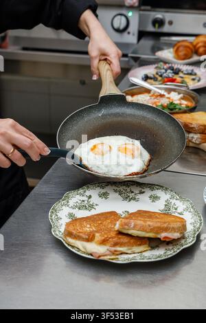 A female chef is preparing breakfasts in a restaurant. Stock Photo
