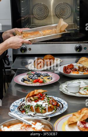 A female chef is preparing breakfasts in a restaurant. Stock Photo