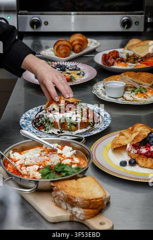 A female chef is preparing breakfasts in a restaurant. Stock Photo
