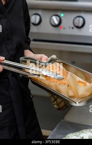 A female chef is preparing breakfasts in a restaurant. Stock Photo