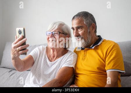 Happy senior couple taking selfie with smartphone at home Stock Photo