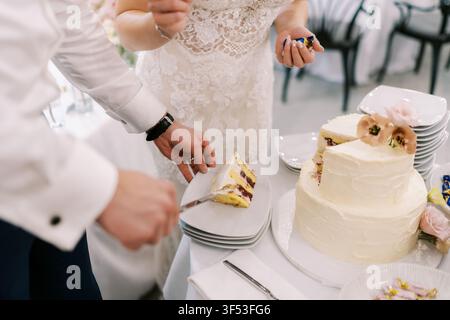Bride and groom cutting wedding cake together Stock Photo