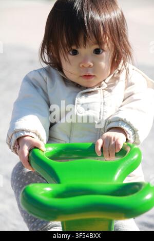Japanese girl on the seesaw (1 year old) Stock Photo