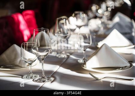 Elegant restaurant table setting featuring crystal wine glasses and folded white napkins on a formal dining table for luxury events and fine dining Stock Photo