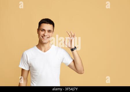 Successful man with gestures celebrating victory. Happy attractive young blogger shows sign okay Stock Photo