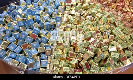 Toronto, ON, Canada - July 30, 2026: Assorted individually wrapped square chocolates are displayed in multiple compartments inside a store. Stock Photo