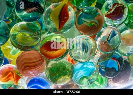 Glass marbles in various colors and patterns creating an abstract background Stock Photo