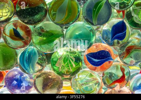 Multicolored glass marbles displaying light and reflections in a full frame background Stock Photo