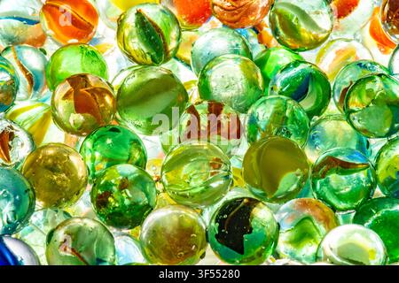 Glass marbles in various colors and patterns forming a translucent, textured background Stock Photo