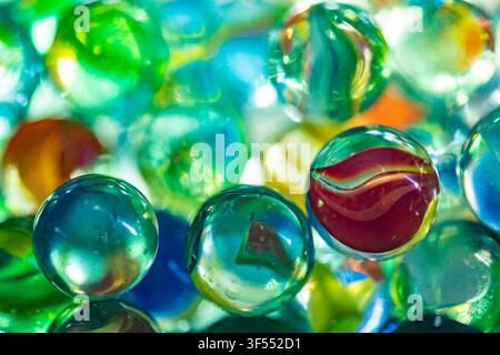 Glass marbles showcasing vibrant colors, translucency, and light reflections Stock Photo
