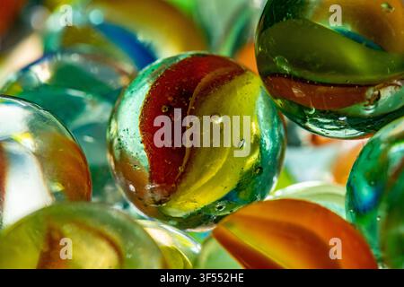 Glass marbles showing vibrant colors, abstract patterns, and reflecting light Stock Photo