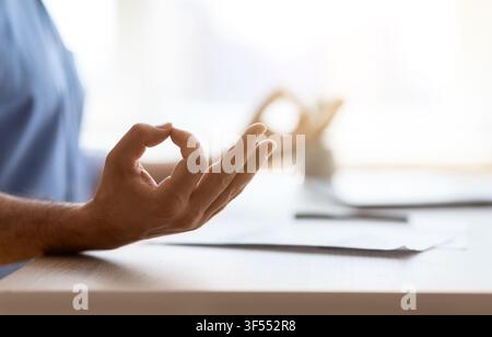Zen. Closeup shot of unrecognizable man meditating while working in office Stock Photo