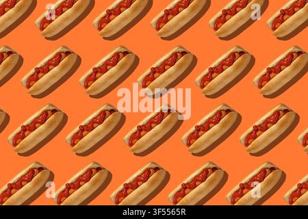 Delicious fast food for lunch in menu. Hot dogs with bun, sausage and red ketchup on orange background Stock Photo