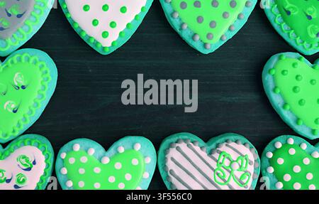 Gorgeous frames of lime green tone heart shaped cookies on black background Stock Photo