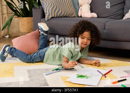 Curly-haired african american boy enjoys drawing and learning through play Stock Photo