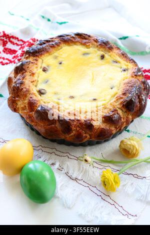 Traditional Romanian Easter cake Pasca with sweet cheese and raisin, decorated with colored eggs and spring flowers.Eastern European  Easter tradition Stock Photo