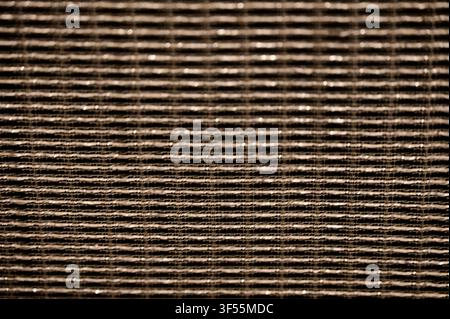 Close-up abstract background texture of a classic brown and gold woven vintage guitar amplifier speaker grille cloth or cabinet mesh. Stock Photo