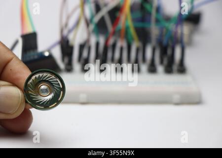 Plastic speaker connected to microcontroller on breadboard background Stock Photo