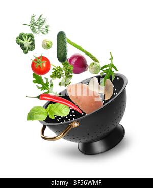 Fresh vegetables and colander in air on white background Stock Photo