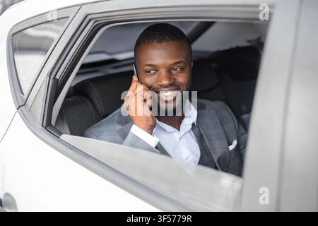 Smiling black businessman having conversation on phone Stock Photo