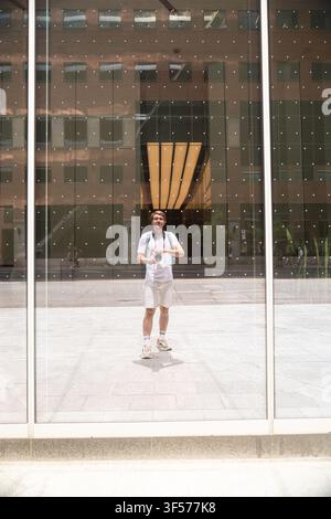Man taking self-portrait reflection in glass building facade Stock Photo