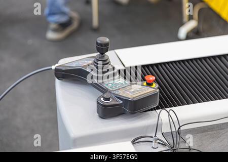 Industrial control panel featuring joystick, buttons, switches, grid layout, illuminated indicators, white surface, industrial setting, workshop ambia Stock Photo