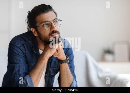 Portrait Of Thoughtful Millennial Arab Guy In Glasses Resting Head On Hands Stock Photo