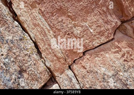 Detail of diagonal cracks in a reddish sandstone rock surface Stock Photo