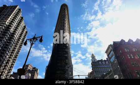 NEW YORK, NY, USA - MAY 15, 2026: The iconic triangular Flatiron Building viewed from street level against a clear blue sky in New York City. Stock Photo