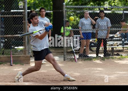 A recreational softball player swings at a pitch on a field in Boston Common, Boston, Massachusetts. Stock Photo