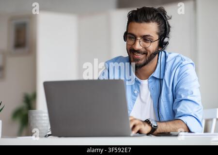 Hotline Operator. Indian Customer Support Manager Man In Headset Working With Laptop Stock Photo
