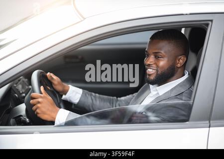 African american young man in suit driving car Stock Photo