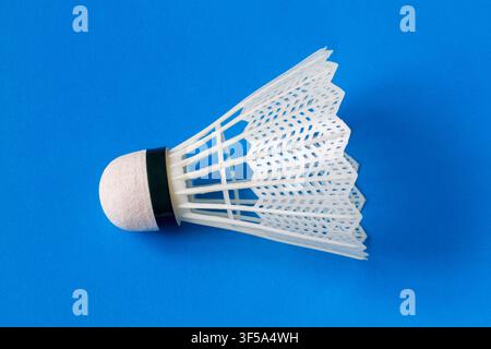 Badminton shuttlecock on a blue background. Shuttlecock close-up. Stock Photo