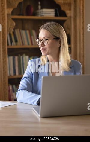 Businesswoman working on laptop at home office Stock Photo