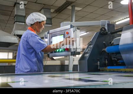 Luanan, China - July 30, 2026: Two Printing Workers Checking Printed Paper Samples Stock Photo