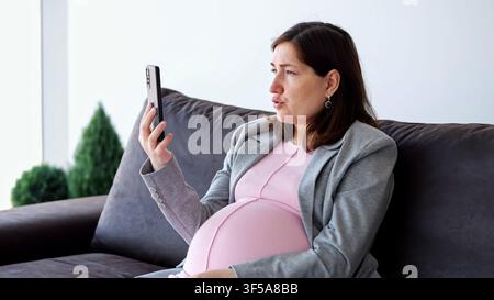 Pregnant woman having business video call Stock Photo