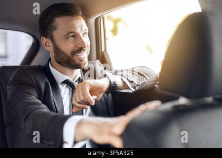 Cheerful businessman looking at his watch, just in time Stock Photo