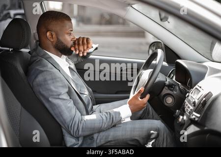 Pensive african american young businessman driving car Stock Photo